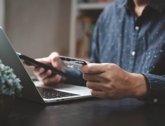 Un homme sur un ordinateur avec une carte bancaire