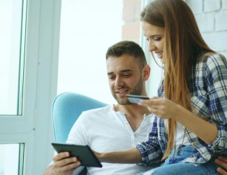 Couple réalisant un achat en ligne avec une tablette et une carte de crédit