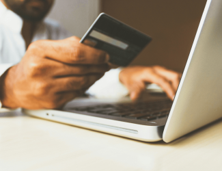 Client devant son ordinateur en train de payer avec sa carte bancaire