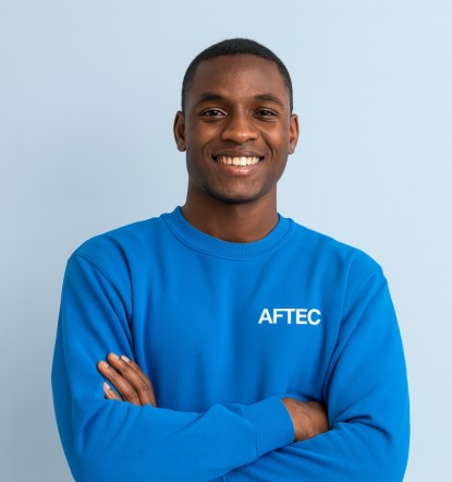 jeune étudiant de 20 ans portant un pull bleu avec le logo AFTEC sur un fond bleu