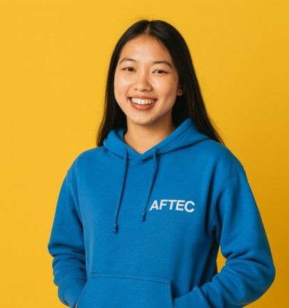 jeune étudiante de 18 ans portant un pull bleu avec le logo AFTEC