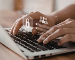 Gros plan sur des mains tapant sur un ordinateur portable, avec une interface numérique de connexion sécurisée affichant un cadenas