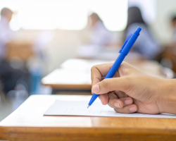 Main tenant un crayon bleu lors d’un examen écrit dans une salle de classe
