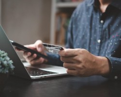 Un homme sur un ordinateur avec une carte bancaire