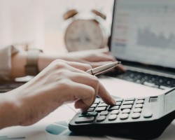 personne qui travaille sur son bureau avec une calculatrice