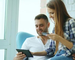 Couple réalisant un achat en ligne avec une tablette et une carte de crédit