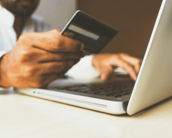 Client devant son ordinateur en train de payer avec sa carte bancaire