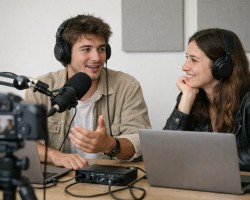 Deux jeunes en train d'enregistrer un podcast vidéo dans un studio simple avec un micro et une caméra, ambiance détendue et professionnelle    