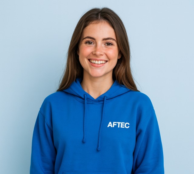 jeune femme de 20 ans portant un sweat bleu à capuche avec le logo AFTEC sur un fond bleu