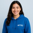 photo d'une alumni de l'école AFTEC, elle porte un sweat bleu à capuche avec le logo AFTEC, sur un fond bleu