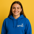 photo de Léane, étudiante en BTS GPME à AFTEC, elle porte un sweat bleu et l'arrière plan est jaune
